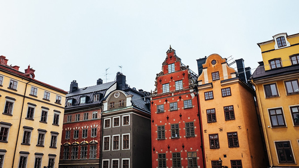 Foto från gamla stan Stockholm. Äldre hus i flera färger vid ett torg.